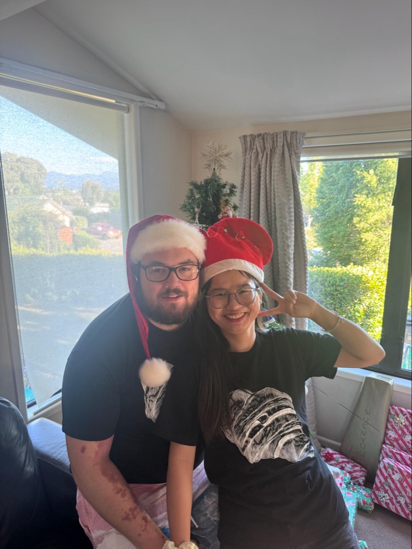 Trang and Robert in Santa hats at Christmas with Robert's family